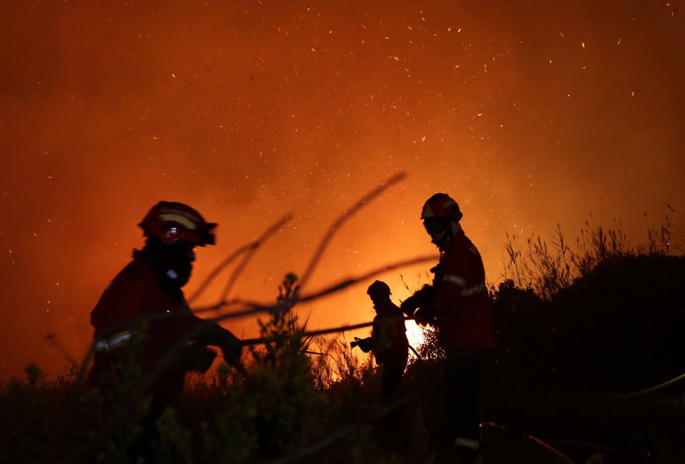 Bombeiros trabalham para conter o fogo em Obidos, em Portugal, nesta segunda-feira (16) (Foto: Armando Franca/ AP)