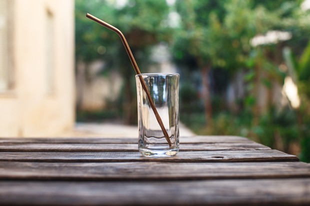An empty glass with a stainless steel straw on a wooden table (Foto: Getty Images/iStockphoto)