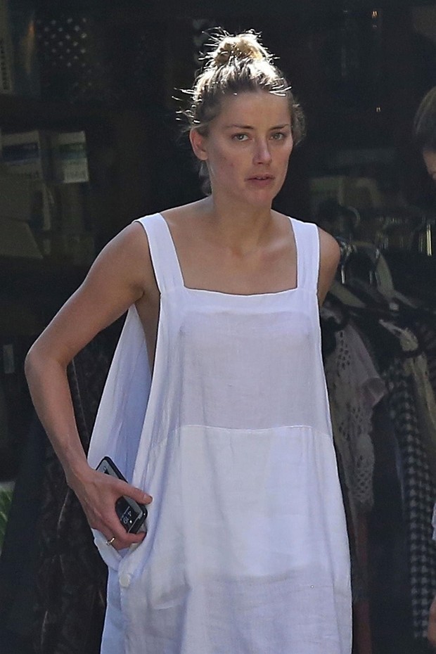 *EXCLUSIVE* Los Angeles, CA  - Actress Amber Heard is seen cleaning out her garage in Los Angeles. Amber who was wearing a white dress and no bra as she had a wardrobe malfunction and exposed her breasts as she bent over. The low cut dress showed off her  (Foto: BACKGRID)