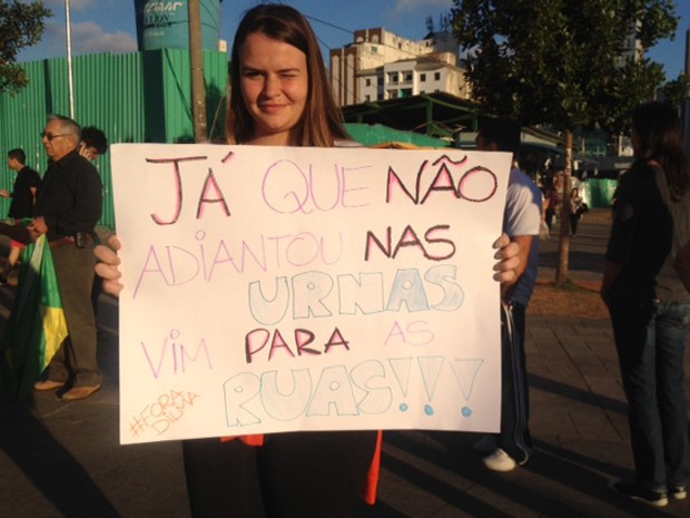 A estudante Nathaly Hackradt, de 19 anos, segura uma faixa de protesto  (Foto: Roney Domingos/G1)
