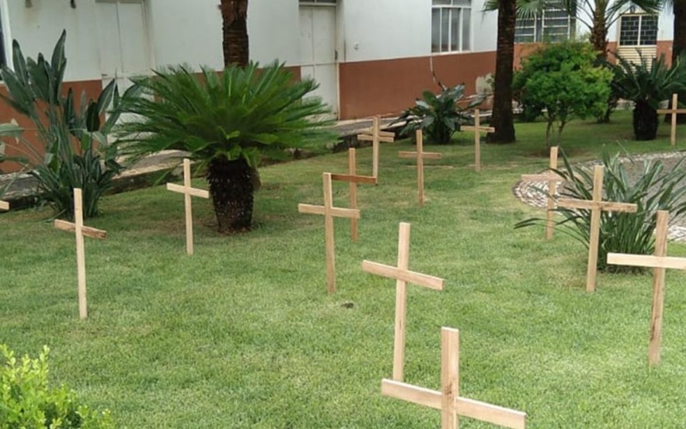 Cruzes são fincadas no jardim de paróquia para lembrar as vítimas da Covid-19 em Itapuranga, Goiás — Foto: Reprodução/TV Anhanguera