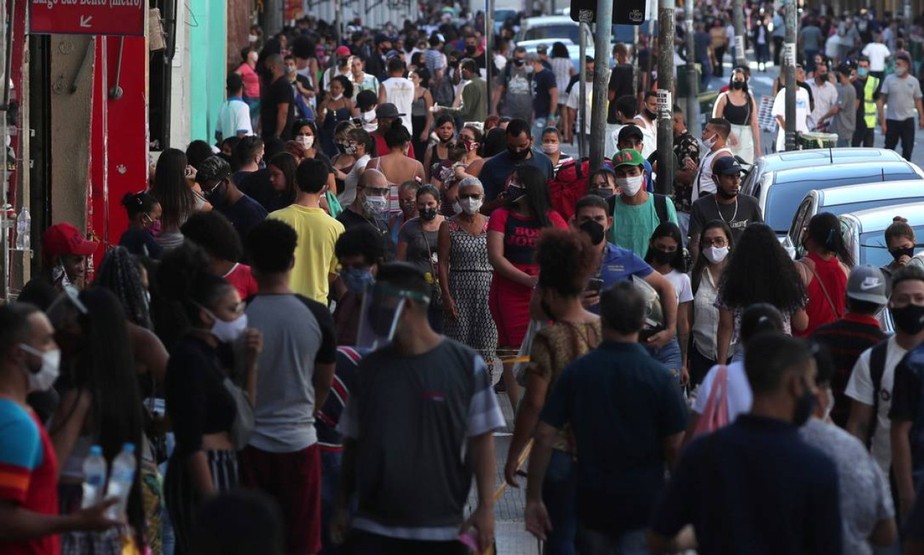 Pessoas caminham por uma rua comercial em São Paulo: projeção de inflação cai para este ano