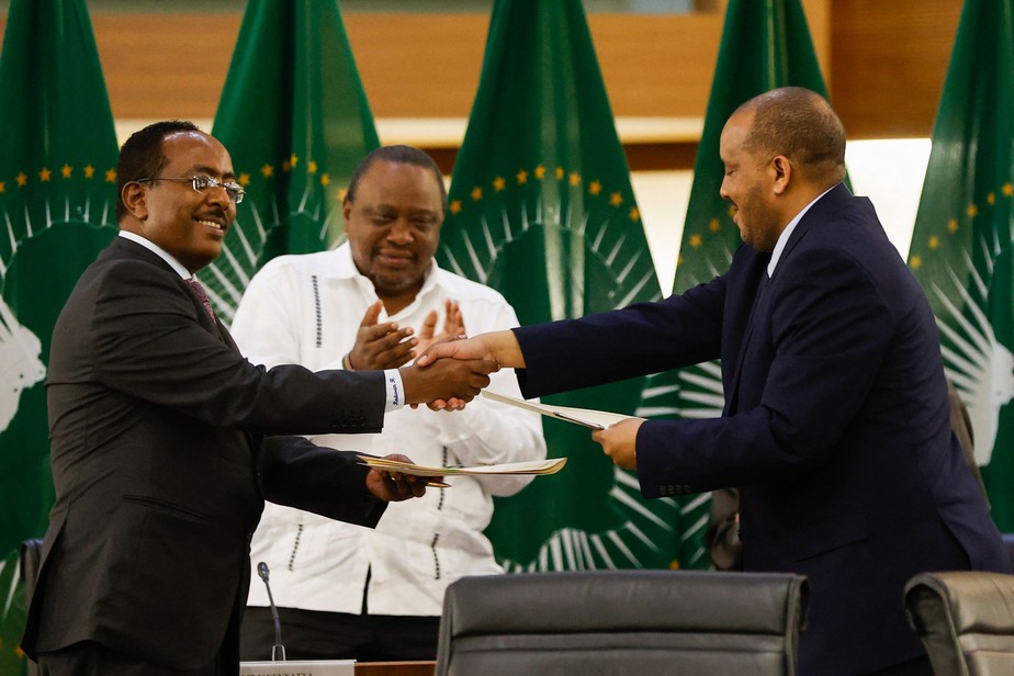 Redwan Hussien Rameto (esquerda),do governo etíope, e Getachew Reda, da Frente de Libertação do Povo Tigré (FLPT) apertam as mãos após a assinatura do acordo, em Pretória