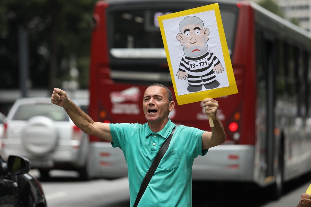 Em São Paulo, homem ergue cartaz com desenho de Lula como presidiário. (Foto: Marcelo Brandt/G1)