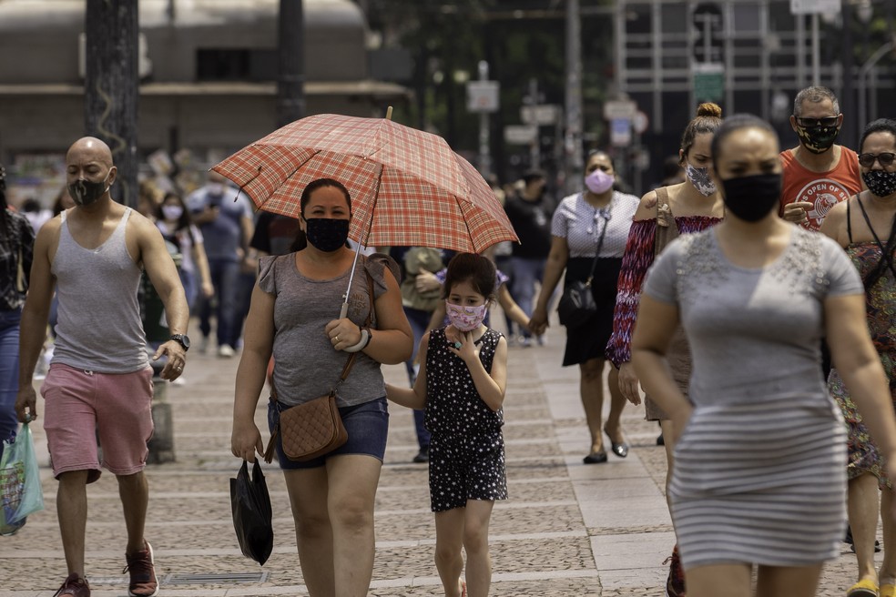 Pessoas caminham e se protegem do sol no Viaduto do Chá, região central de São Paulo, na tarde desta quarta-feira (07) — Foto: Bruno Rocha/Estadão Conteúdo