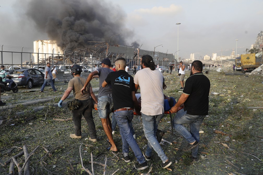 Civis carregam vítima após explosão em Beirute, no Líbano — Foto: Hussein Malla/AP