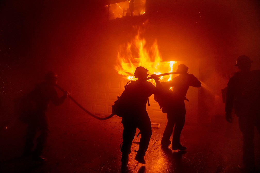 Bombeiros trabalham para combater o incêndio conhecido localmente como Hillside e evitar que ele se espalhe para outras casas em San Bernardino, na Califórnia, EUA — Foto: Christian Monterrosa/AP