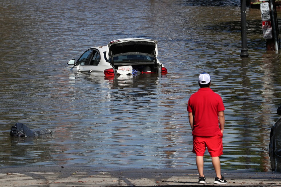 Um homem olha para um carro inundado em Mamaroneck, Nova York, nesta quinta (2), após a passagem da tempestade tropical Ida    — Foto: Mike Segar/Reuters
