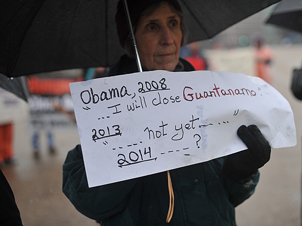 Mulher segura cartaz em que lembra promessa de 2008 feita pelo presidente Obama (Foto: Nicholas Kamm/AFP)