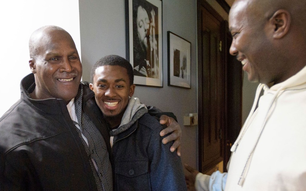 Malcolm Alexander é visto pouco após ser libertado, abraçando seu neto, Malcolm Stewart Jr., ao lado do filho, Malcolm Stewart, em Nova Orleans, Louisiana, na terça-feira (30) (Foto: Matthew Hinton /The Advocate via AP)
