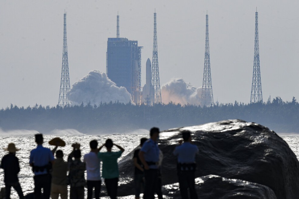Moradores de Hainan, no centro da China, observam lançamento do foguete Longa Marcha-5B Y4 para terminar a construção da estação espacial chinesa, em 31 de outubro de 2022. (Foto: Yang Guanyu/Xinhua via AP)