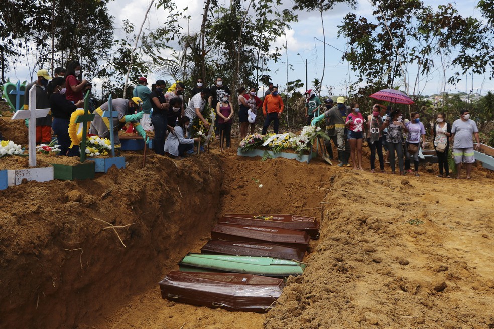 Imagem feita em 21 de abril de 2020: familiares acompanham enterro coletivo no cemitério Nossa Senhora Aparecida, em Manaus — Foto: AP Foto/Edmar Barros