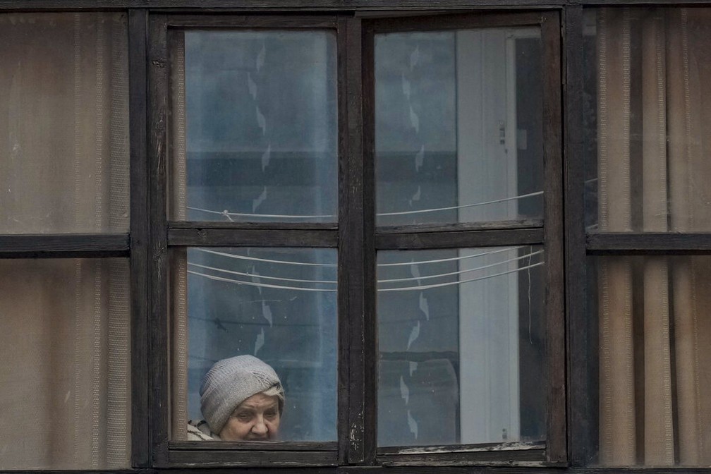 Uma mulher olha pela janela de uma casa em Sievierodonetsk, na regio de Luhansk, no leste da Ucrnia.  Foto: AP Foto/Vadim Ghirda