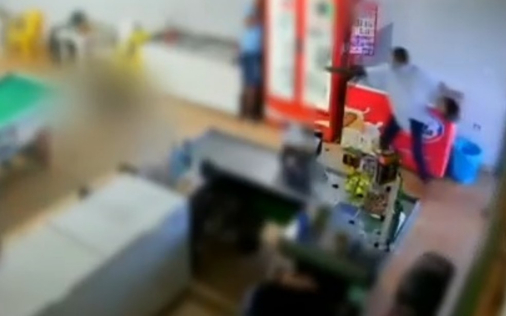 Imagem mostra quando criminoso atira na vítima em um bar de Goianésia, Goiás — Foto: TV Anhanguera/Reprodução
