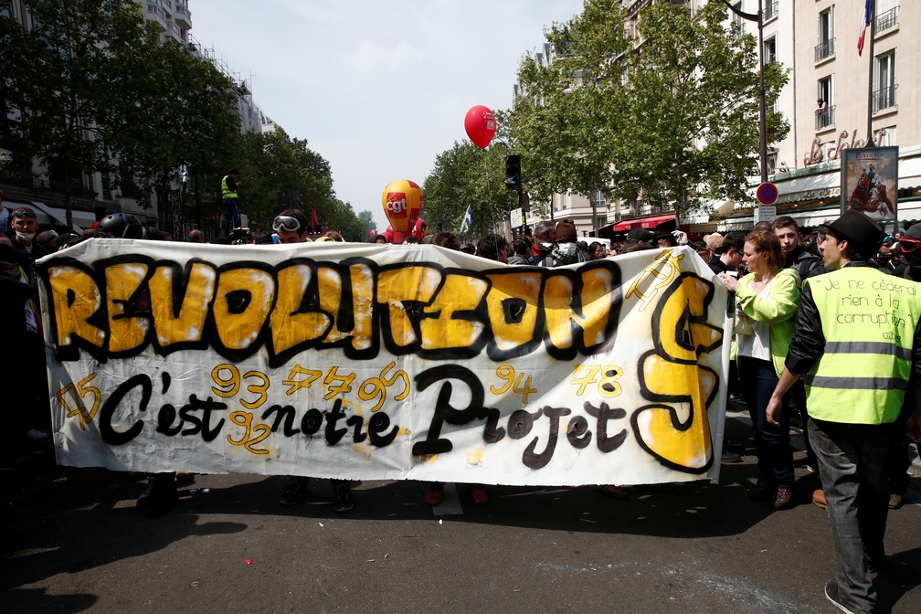 Manifestantes seguram um banner durante protestos do Dia do Trabalho, nesta quarta-feira (1º), em Paris. — Foto: Benoit Tessier/Reuters