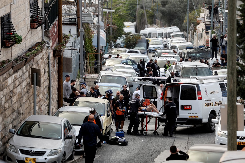 Funcionários do serviço de emergência de Israel socorrem dois feridos após um ataque em Jerusalém, em 28 de janeiro de 2023. — Foto: Ammar Awad/ Reuters