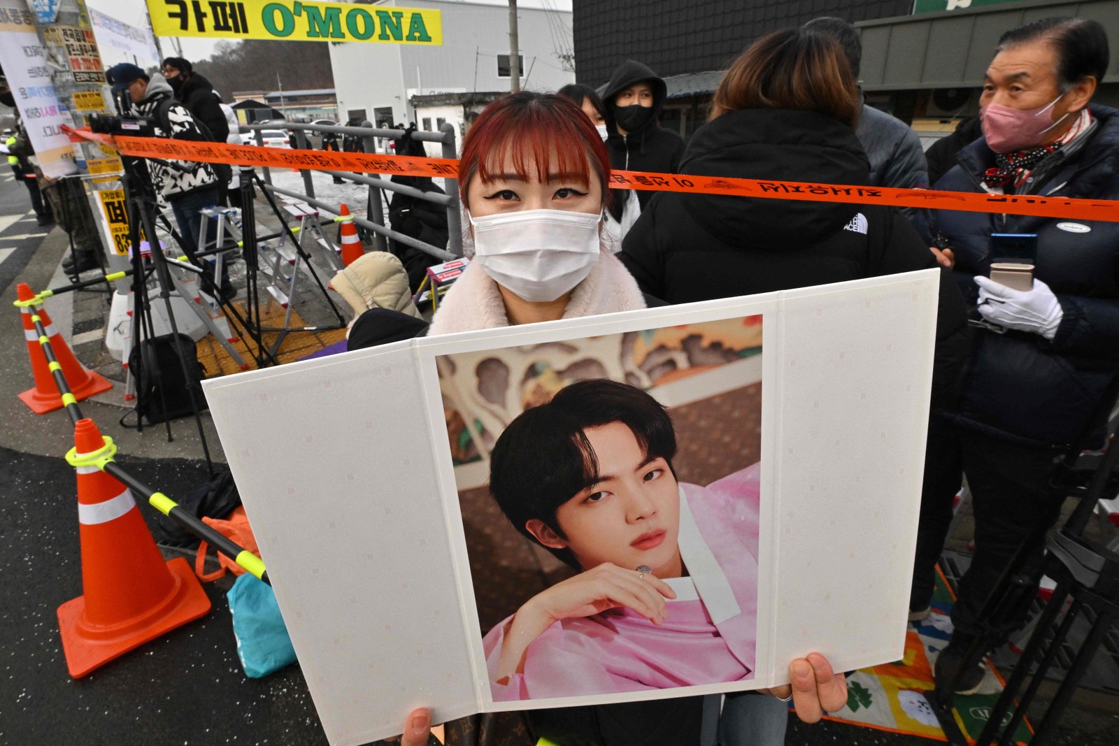 Fã segura uma foto do cantor sul-coreano Jin, do BTS,  em frente a unidade de treinamento em Yeoncheon, onde ele cumprirá seu serviço militar obrigatório.  — Foto: Jung Yeon-je / AFP