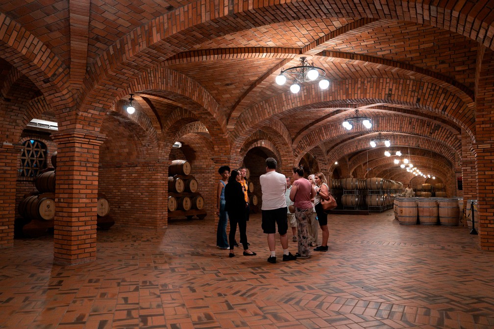 Guiados, turistas passeiam por cava subterrânea em vinícola de Bento Gonçalves — Foto: Marcelo Brandt/G1