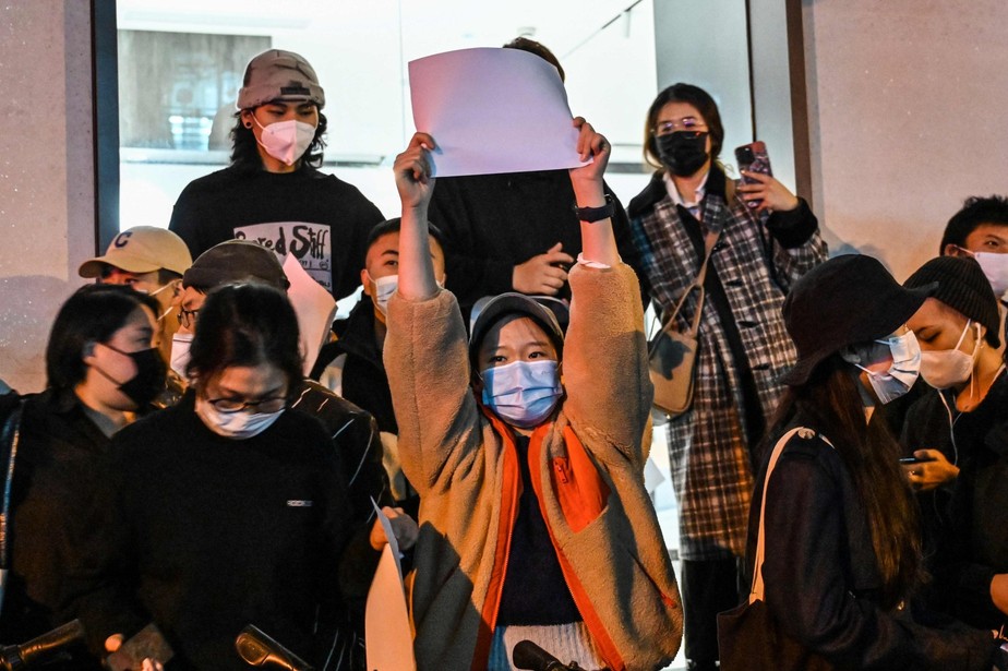Manifestante carrega papel em branco durante ato em Xangai