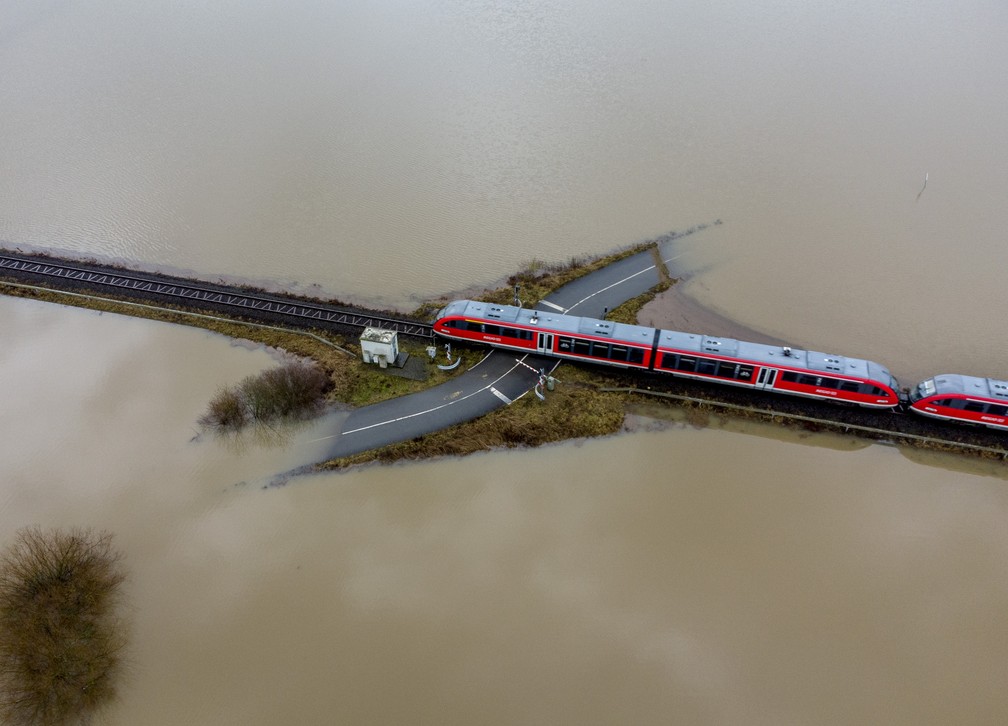 3 de fevereiro - Trem passa por uma ferrovia cercada por enchentes de chuva e neve derretida em Nidderau, perto de Frankfurt, Alemanha — Foto: Michael Probst/AP