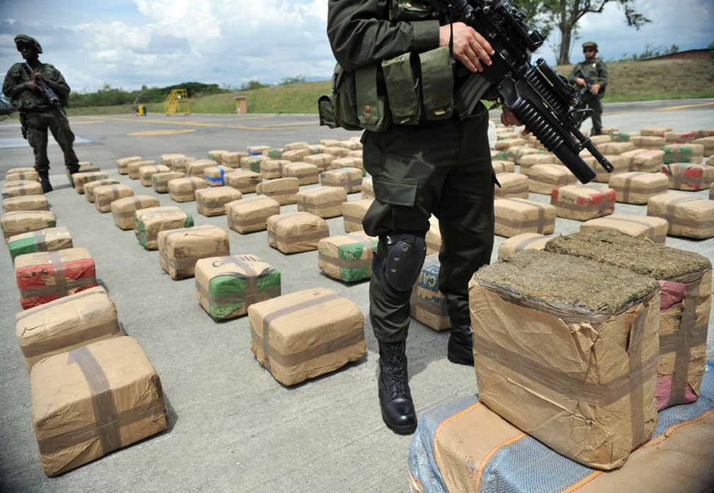 Policiais colombianos exibem droga apreendida na base aérea de combate às drogas em Tulua na Colômbia. Quatro toneladas de maconha supostamente das FARC na cidade de Buga. (Foto: Guillermo Legaria/AFP)