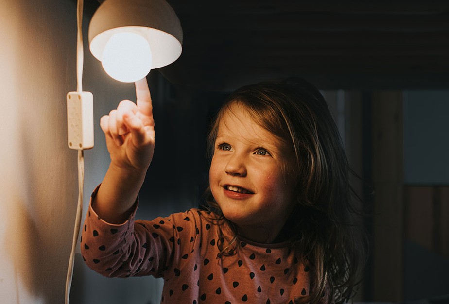 Criança mexendo em lâmpada