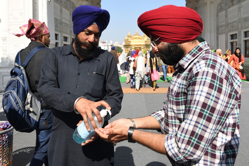 Devoto sikh usa álcool gel antes de entrar no Templo Dourado em Amritsar, na Índia, nesta terça-feira (17) — Foto: Narinder Nanu / AFP