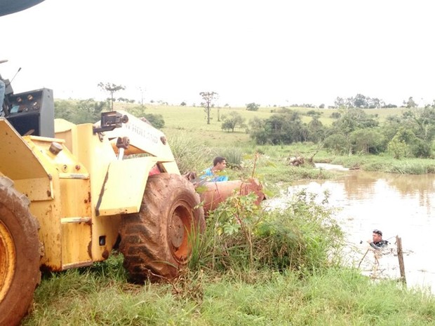 Trator ajuda na retirada do veículo que caiu no córrego  (Foto: Victor Gomes/TV TEM)