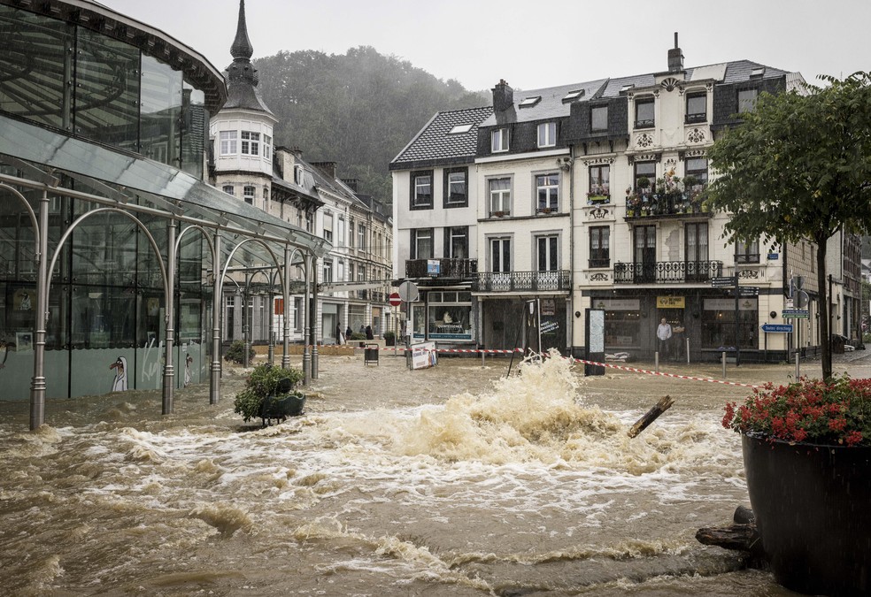 Lojista observa enchente criar "rio" na principal rua do centro de Spa, na Bélgica, em 14 de julho de 2021 — Foto: Valentin Bianchi/AP