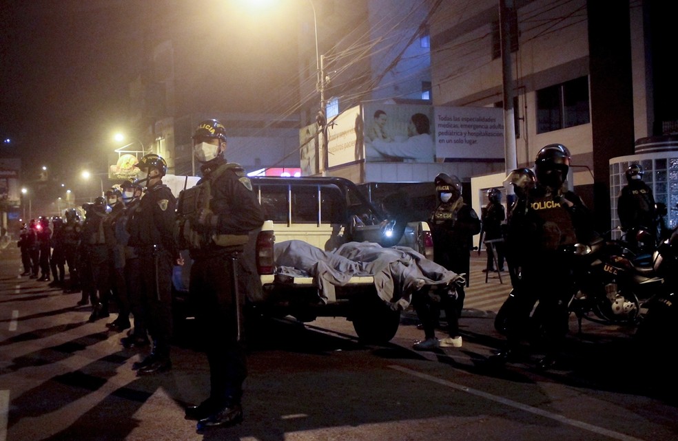 Policiais colocam corpos dentro de caminhão após operação que deixou 13 mortos em Lima, no Peru — Foto: AP Photo/Diego Vertiz