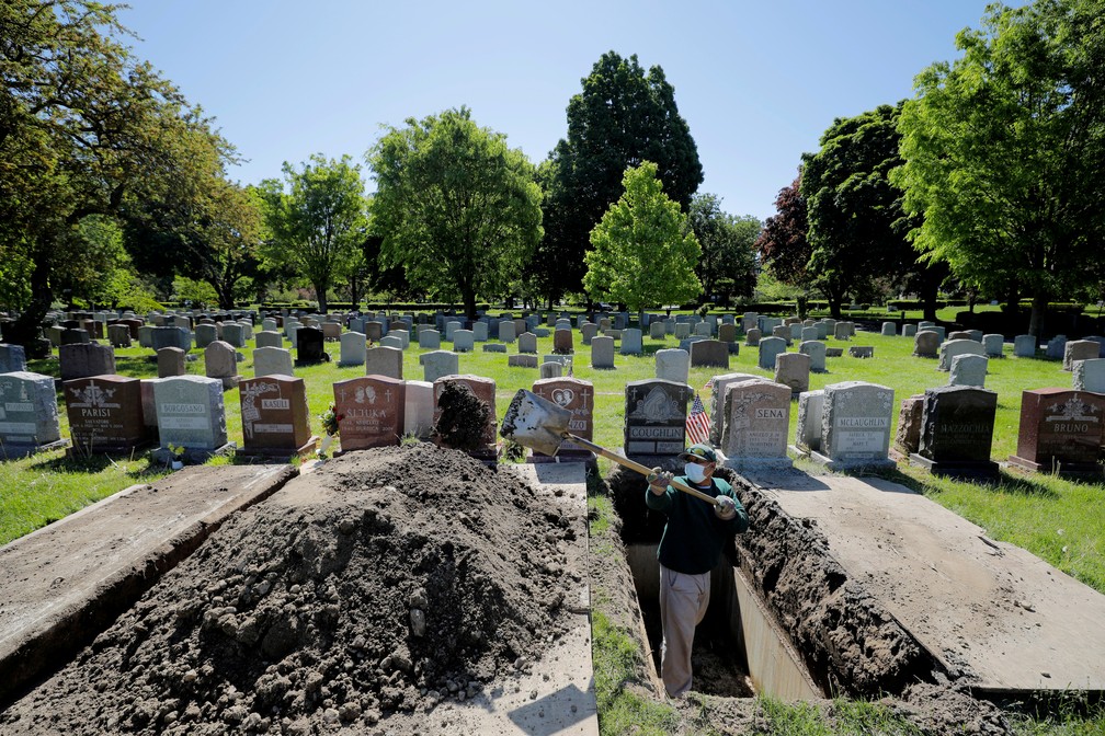 Maio de 2020: Roberto Arias prepara cova para enterro no cemitério Woodlawn durante a pandemia do novo coronavírus (COVID-19) em Everett, no estado de Massachusetts, nos Estados Unidos — Foto: Brian Snyder//Reuters