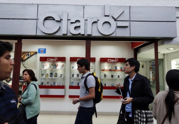 Clientes caminham diante de loja da operadora Claro em Lima (Foto: Mariana Bazo/Reuters)