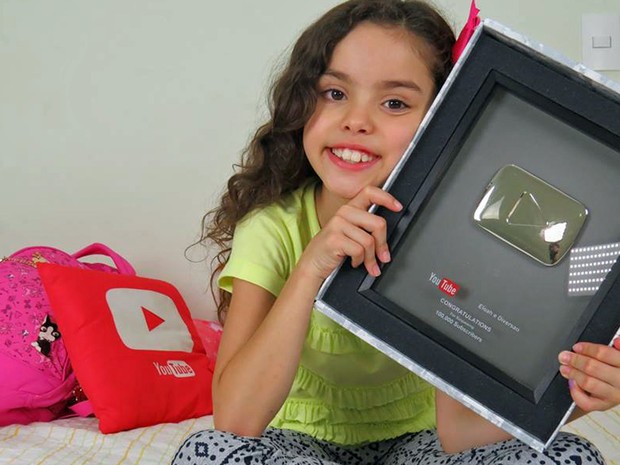 Eloah Lourenço, de 9 anos, segura a placa de 100 mil inscritos no canal do Youtube (Foto: Elaine Lourenço/Arquivo Pessoal)