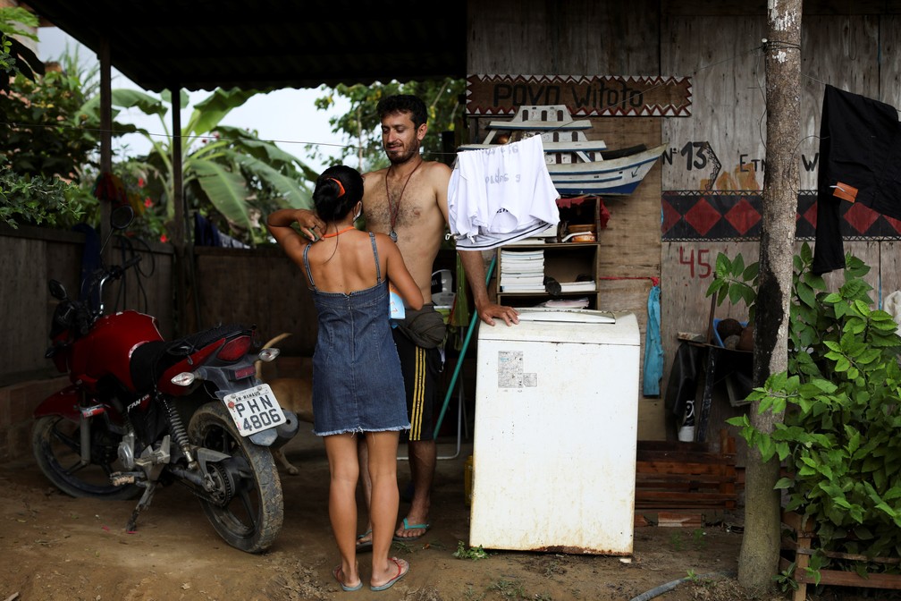 Vanda conversa com o marido Sidnei dos Santos do lado de fora de casa — Foto: Bruno Kelly/Reuters