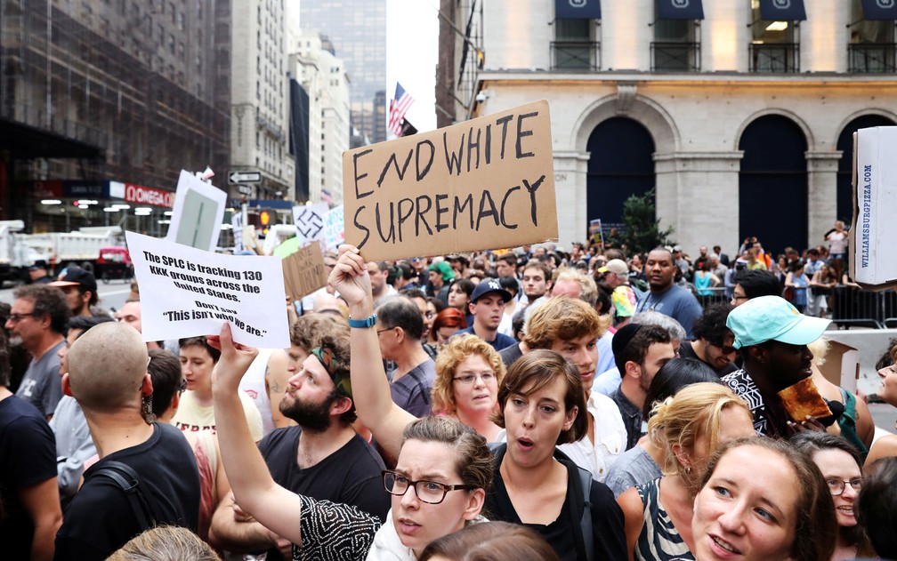 Manifestantes exibem cartazes contra o movimento de supremacistas brancos do lado de fora da Trump Tower, em Nova York, na segunda (14) (Foto: Reuters/Shannon Stapleton)