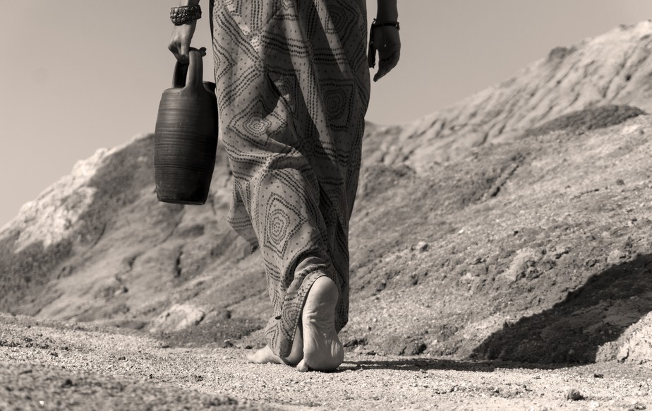 Mulher caminha em região seca em busca de água