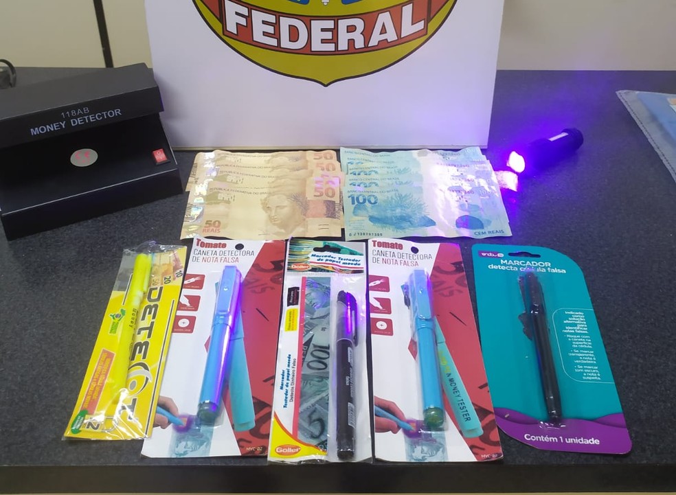 Na casa de jovem de 21 anos havia dinheiro falso e canetas que servem para checar identificação da moeada — Foto: PF/Divulgação