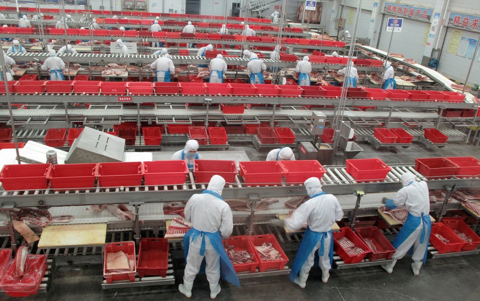 Funcionários de frigorífico na China embalam cortes de porco — Foto: Dominique Patton/Reuters