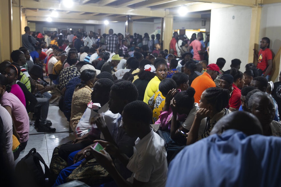 Haitianos sentam-se dentro de um escritório de imigração enquanto esperam a vez de solicitar um passaporte, em Porto Príncipe, Haiti, terça-feira, 10 de janeiro de 2023 — Foto: AP Photo/Odelyn Joseph