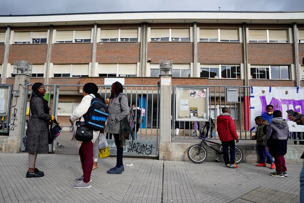 Pais e alunos deixam escola primária depois do anúncio de fechamento de escolas em Vitoria, no País Basco espanhol. — Foto: Vincent West/Reuters