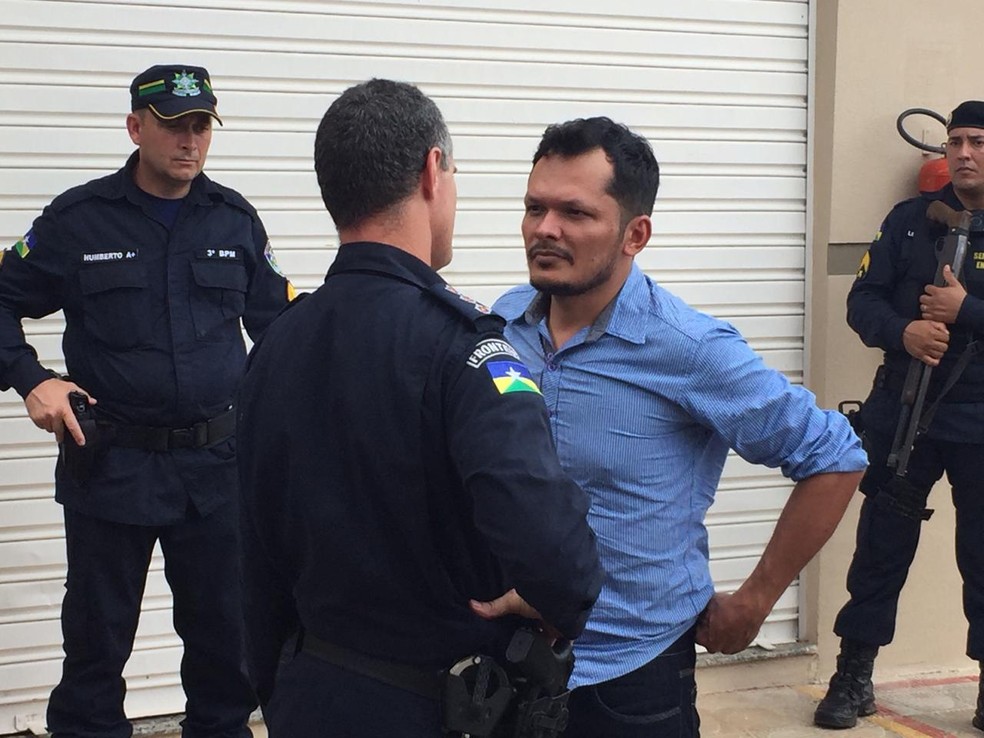 Ismael em pé e de camisa azul conversando com um policial antes de ser levado para a Casa de Detenção. — Foto: Renato Barros/Rede Amazônica