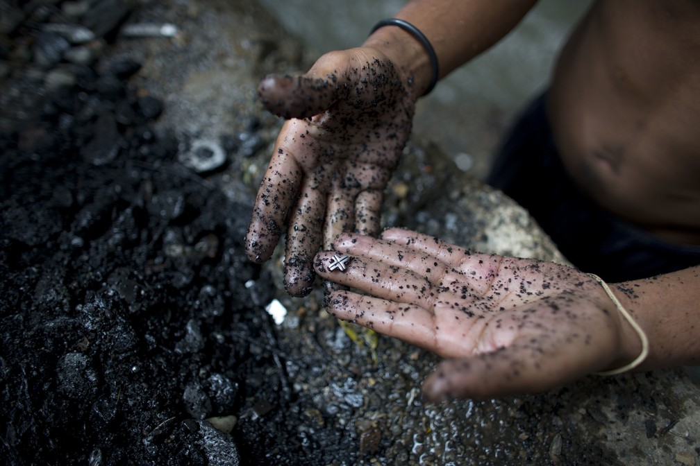 'Garimpeiro' do Rio Guaire mostra cruz de prata que achou no Rio Guaire, em Caracas (Foto: Ariana Cubillos/AP Photo)