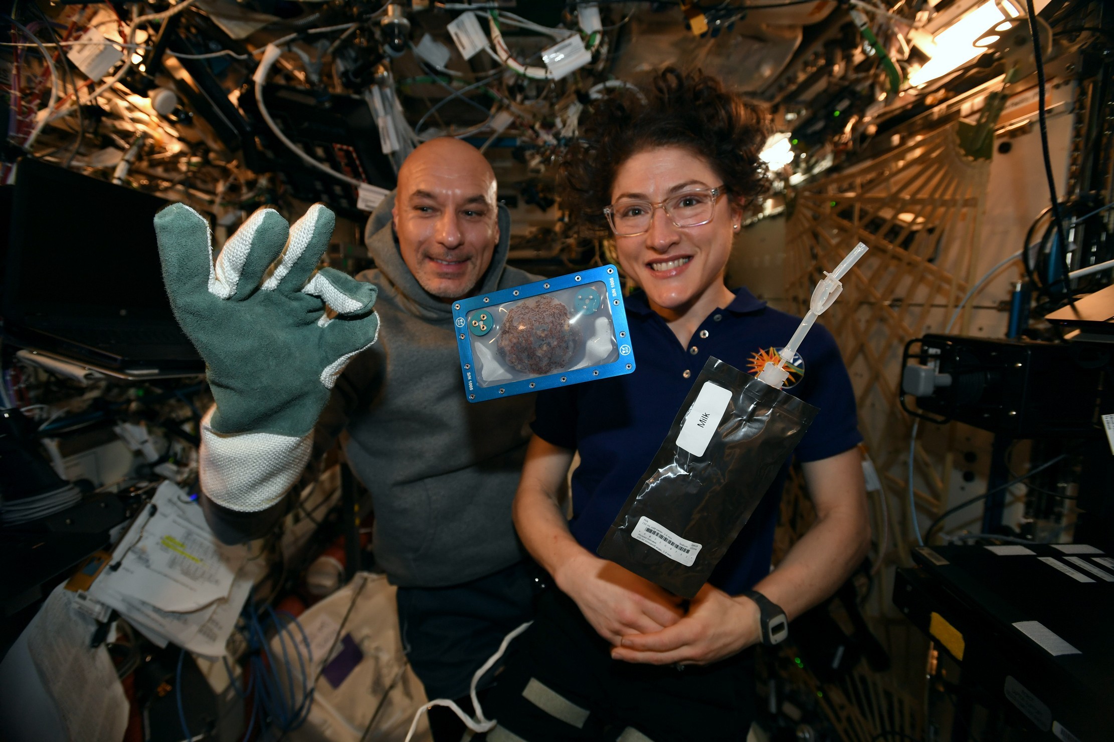 Foto publicada pela astronauta Christina Koch no Twitter mostra cookie feito na Estação Espacial Internacional, ao lado do astronauta italiano Luca Parmitano   (Foto: NASA via AP)