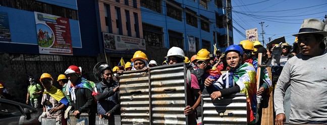 Indígenas usam escudos improvisados em protesto. O governo do Equador suspendeu as negociações com manifestantes depois da morte de um soldado que, segundo ministro do governo de Guillermo Lasso, foi vítima de "manifestantes violentos" — Foto: MARTIN BERNETTI / AFP