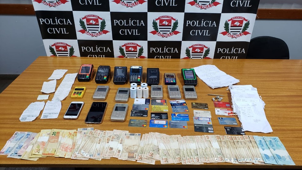 Polícia apreendeu 19 cartões, 14 máquinas de cartão, mais de R$ 3,8 mil e outros objetos utilizados no crime  — Foto: Polícia Civil