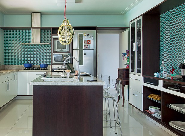 Azulejos retrô esverdeados revestem a cozinha projetada pela arquiteta Andrea Murao. A cor está presente em outras partes da decoração, como o sofá e a porta de correr (Foto: Cacá Bratke/Casa e Jardim)