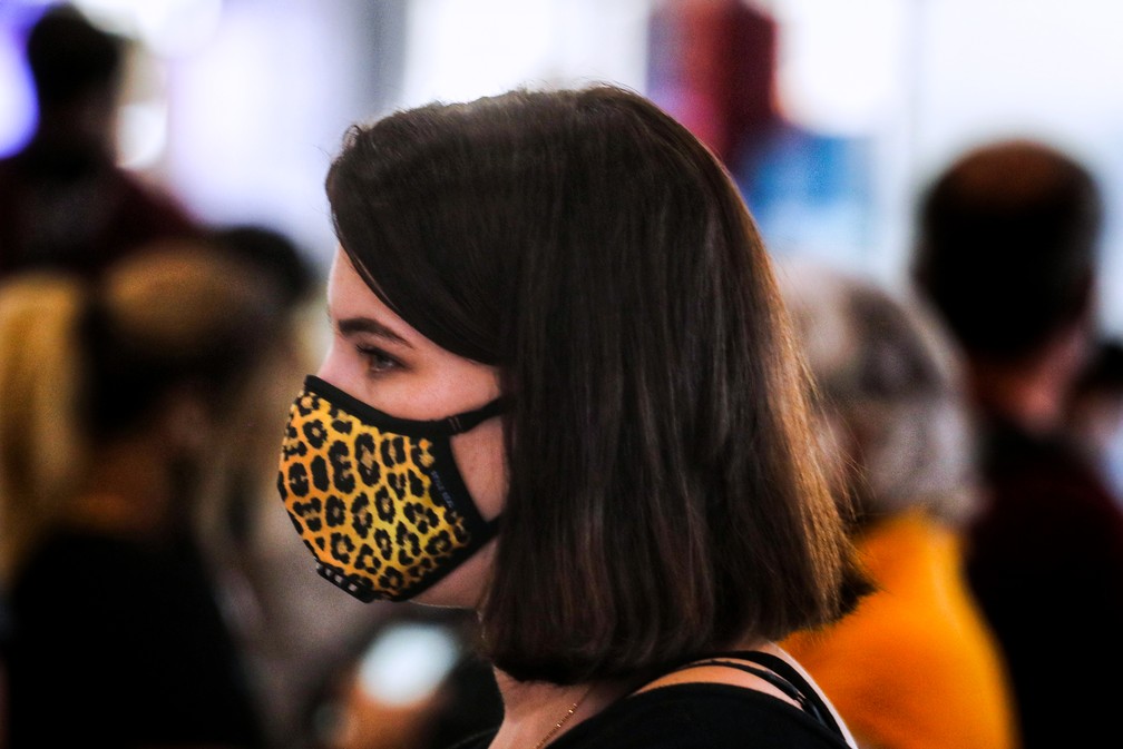 Mulher é vista usando máscara de proteção enquanto espera na área de check-in do aeroporto de Suvarnambhumi, em Bangcoc — Foto: Vivek Prakash/AFP