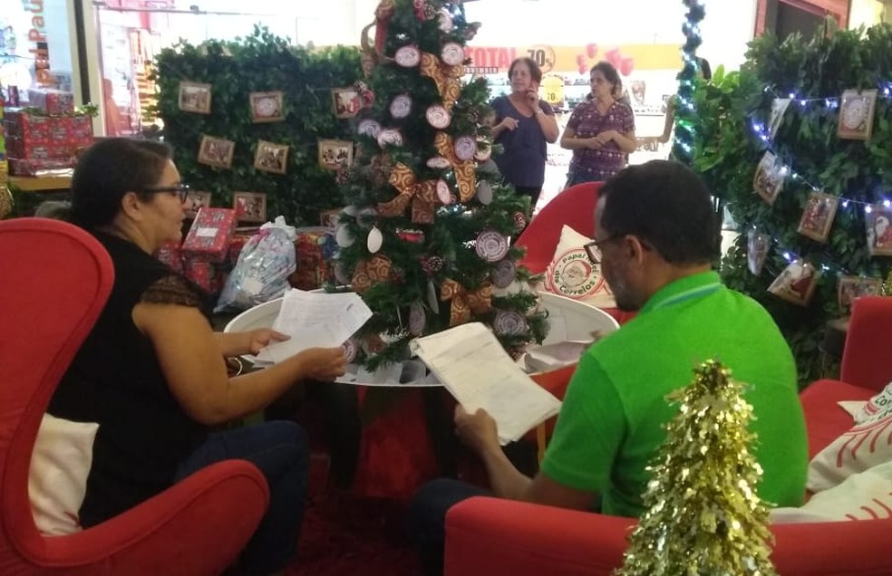 Casal Flávio Henrique e Rosiane de Araújo passou um bom tempo lendo as cartinhas de Natal das crianças, em Maceió  — Foto: Matheus Tenório/G1