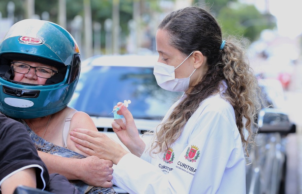 Profissional aplica vacina contra gripe em idosa, em Curitiba — Foto: Giuliano Gomes/PRPress