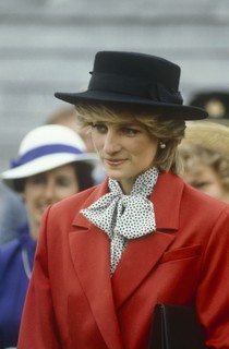 Em 1983, usando um terno vermelho-tomate por cima de uma blusa de poá preta e branca com um laço   